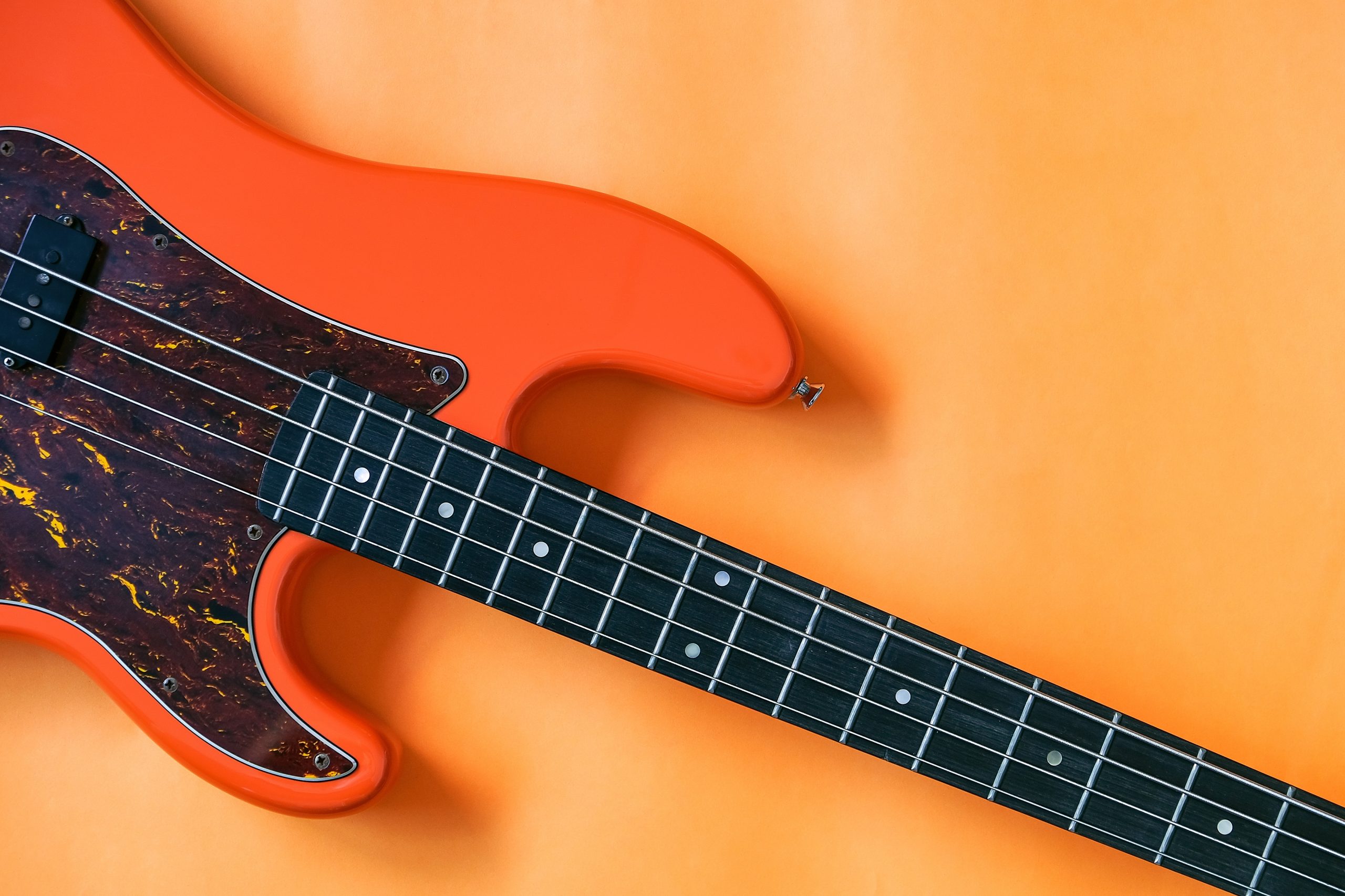 orange bass guitar on orange background