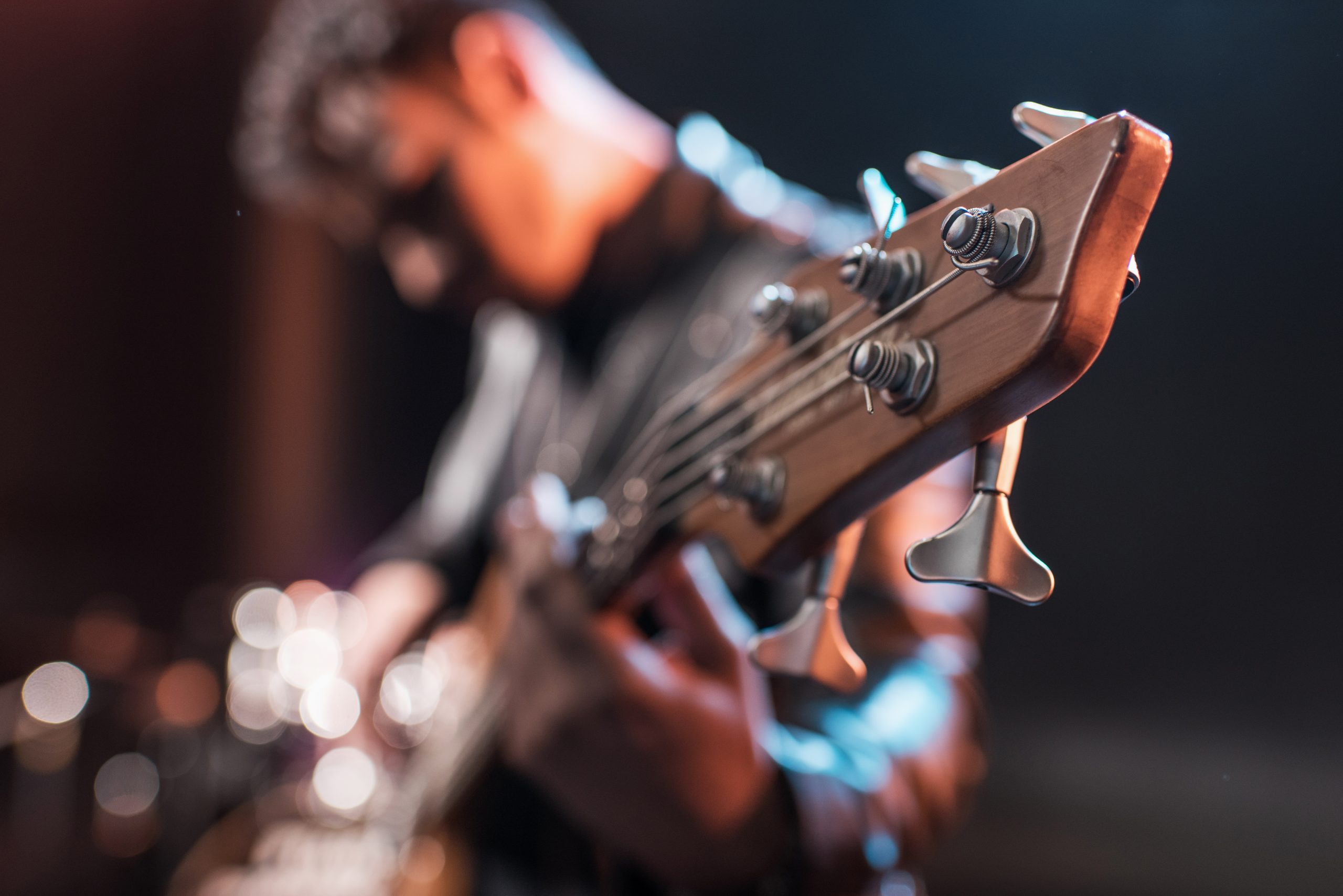 man holding a 5 string bass guitar