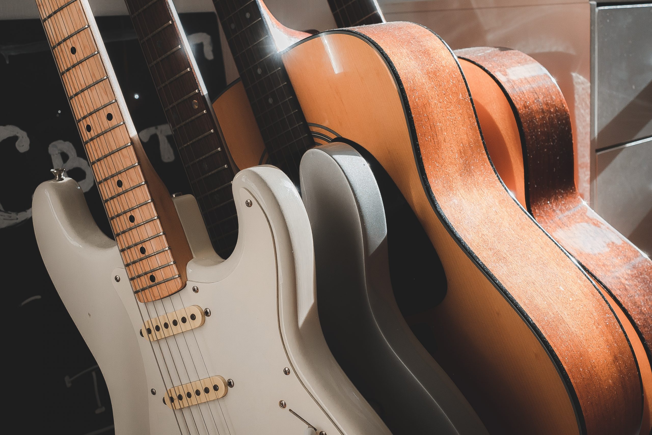 electric and acoustic guitars on a rack