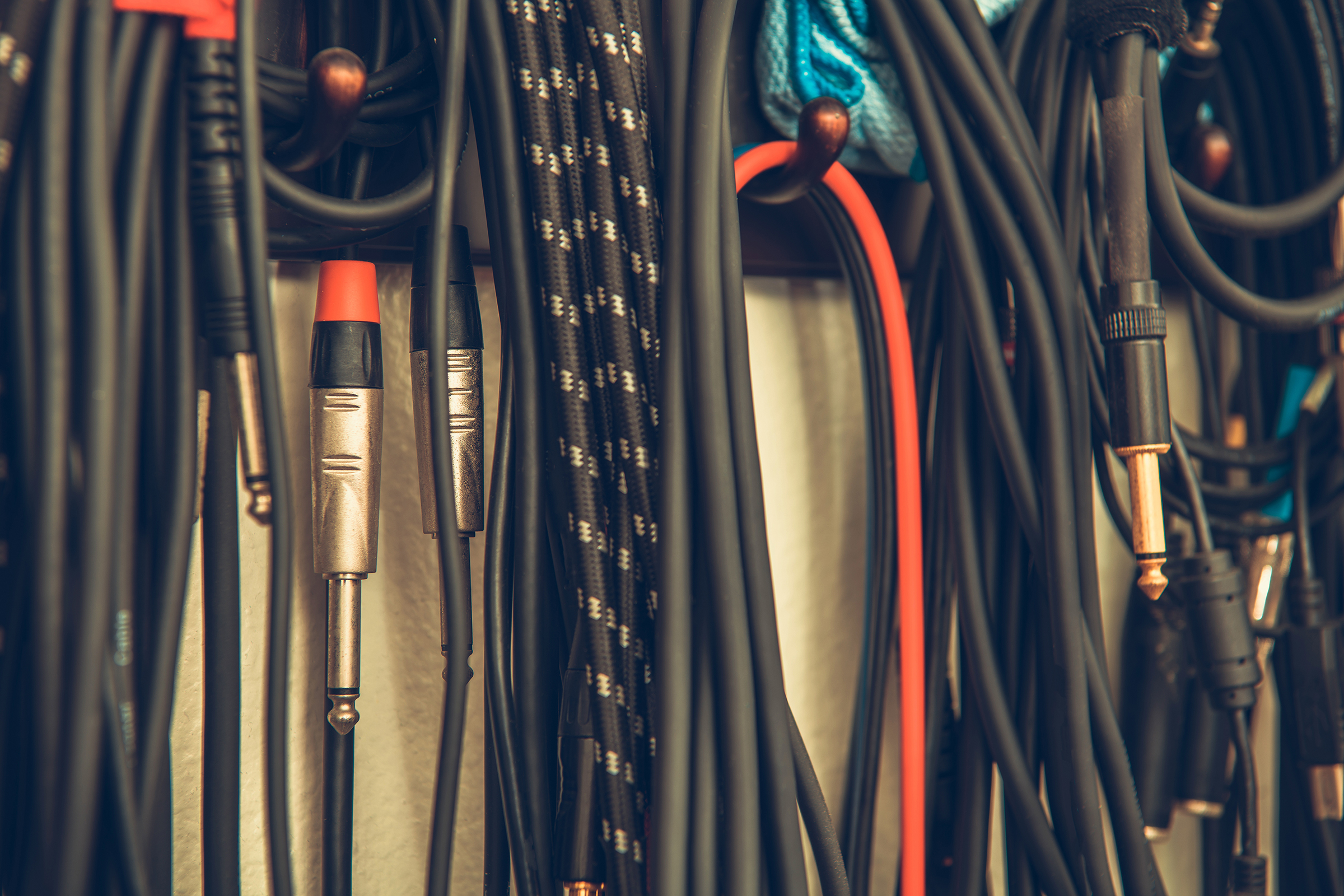 different types of guitar cables hanging on wall