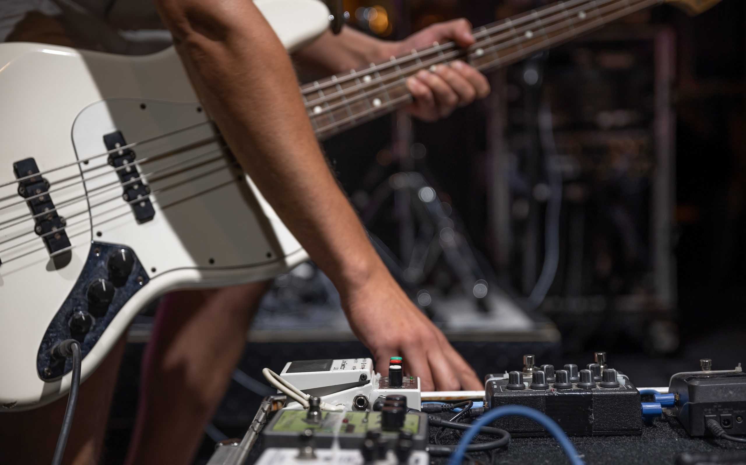 closeup of hand deciding how to set up guitar pedals